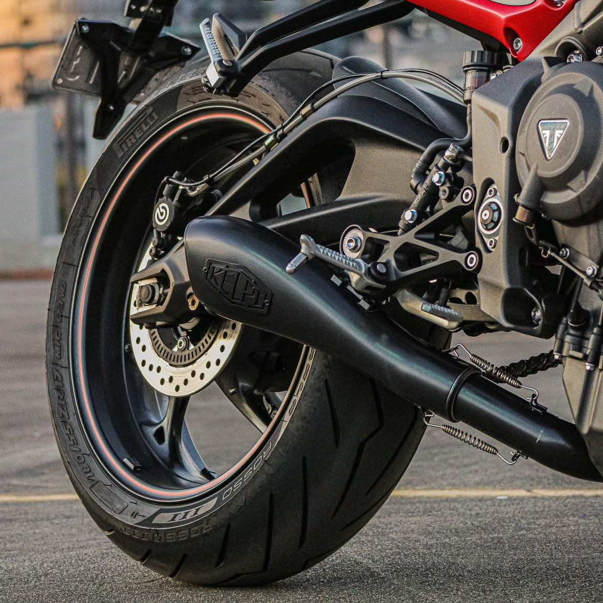 A black cerakoted Alpha muffler installed on a Triumph Street Triple