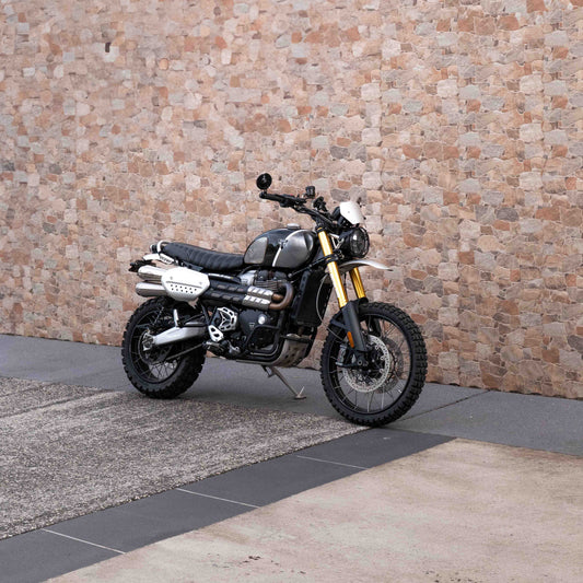 A triumph scrambler 1200 with a Kelpi Custom seat, exhaust, Rounder Mirrors and Tracker 7050 Fat bars
