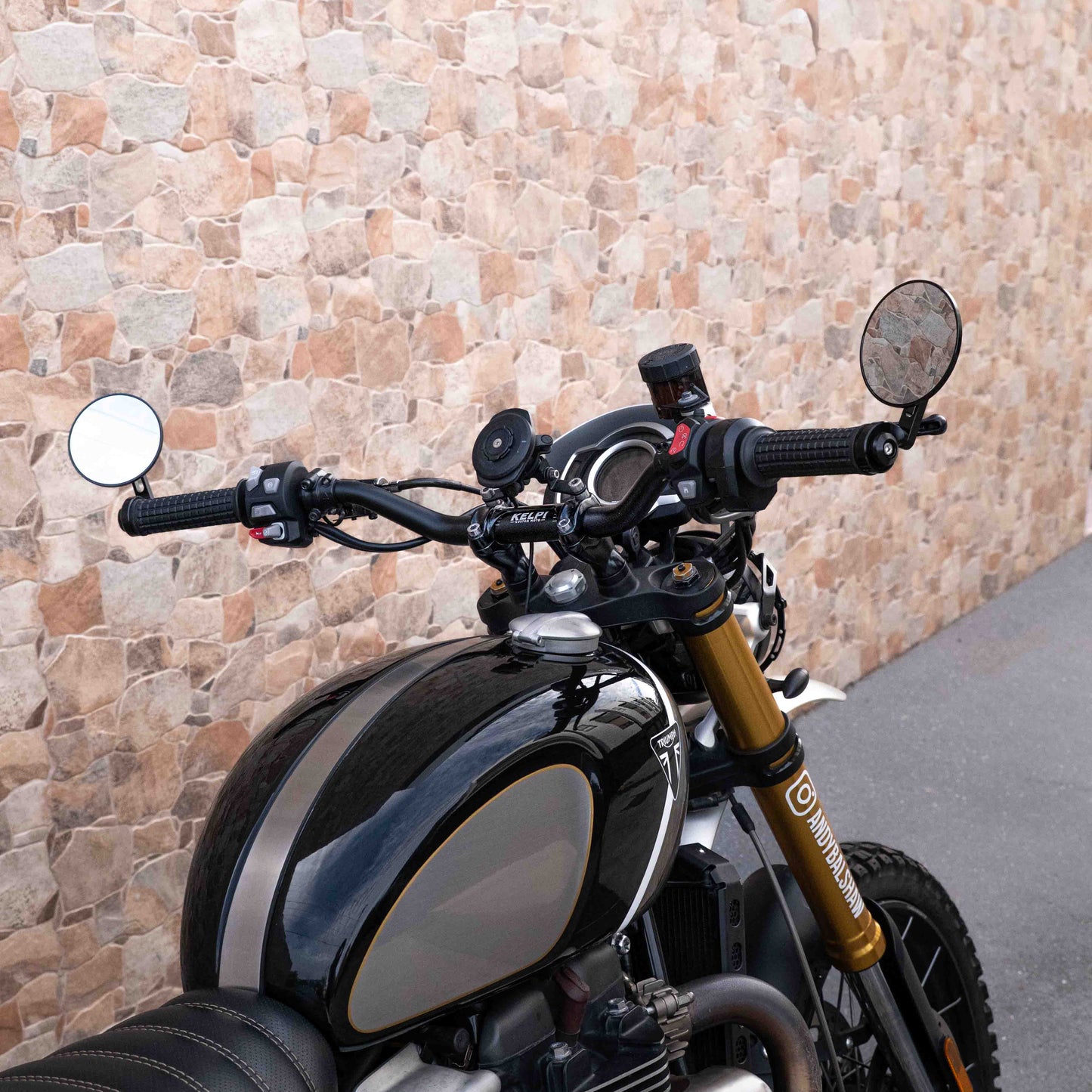 A triumph scrambler 1200 with a Kelpi Custom Moto Tracker 7050 Fat bars, rounder mirrors and fitzroy grips