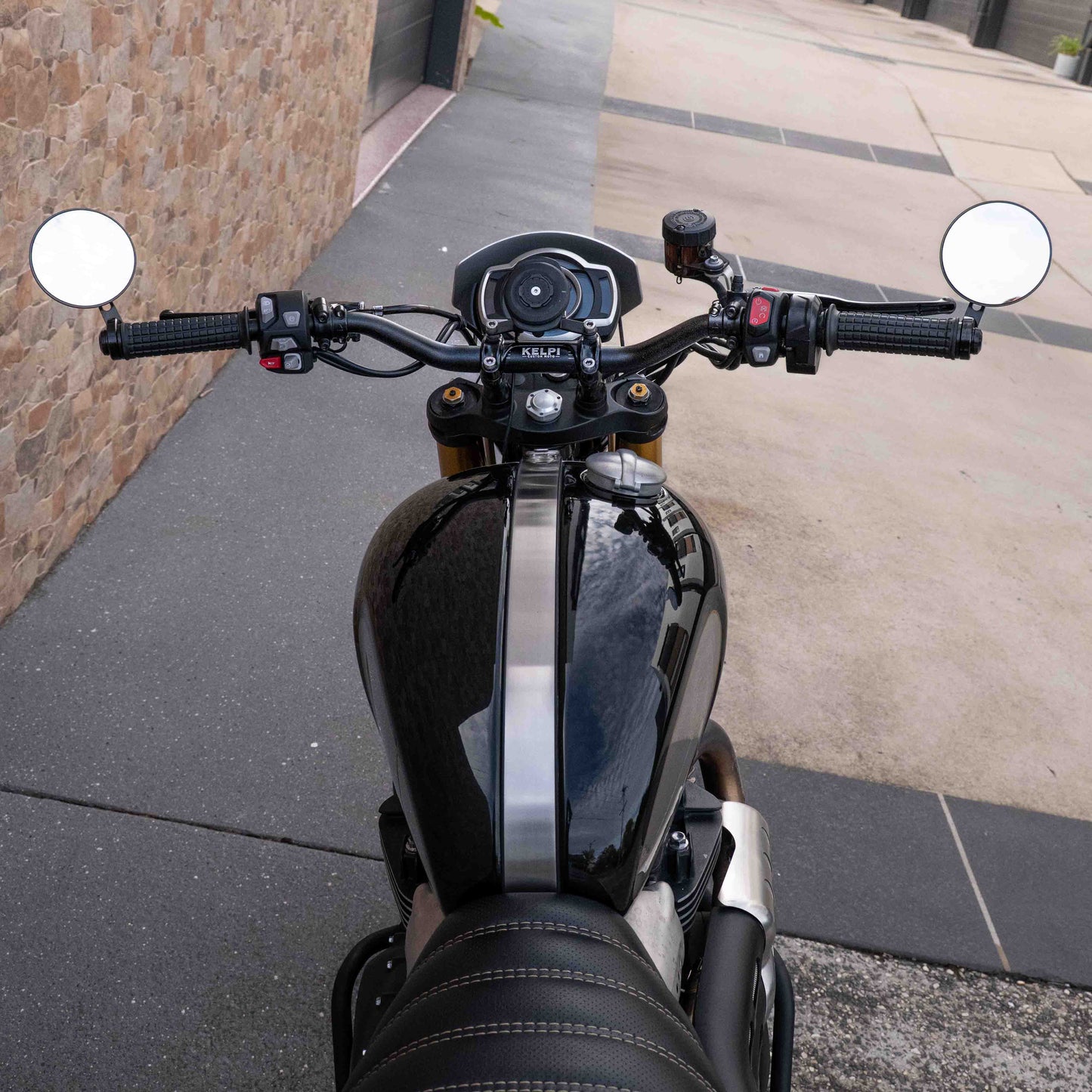 A triumph scrambler 1200 with a Kelpi Custom Moto Tracker 7050 Fat bars, rounder mirrors and fitzroy grips