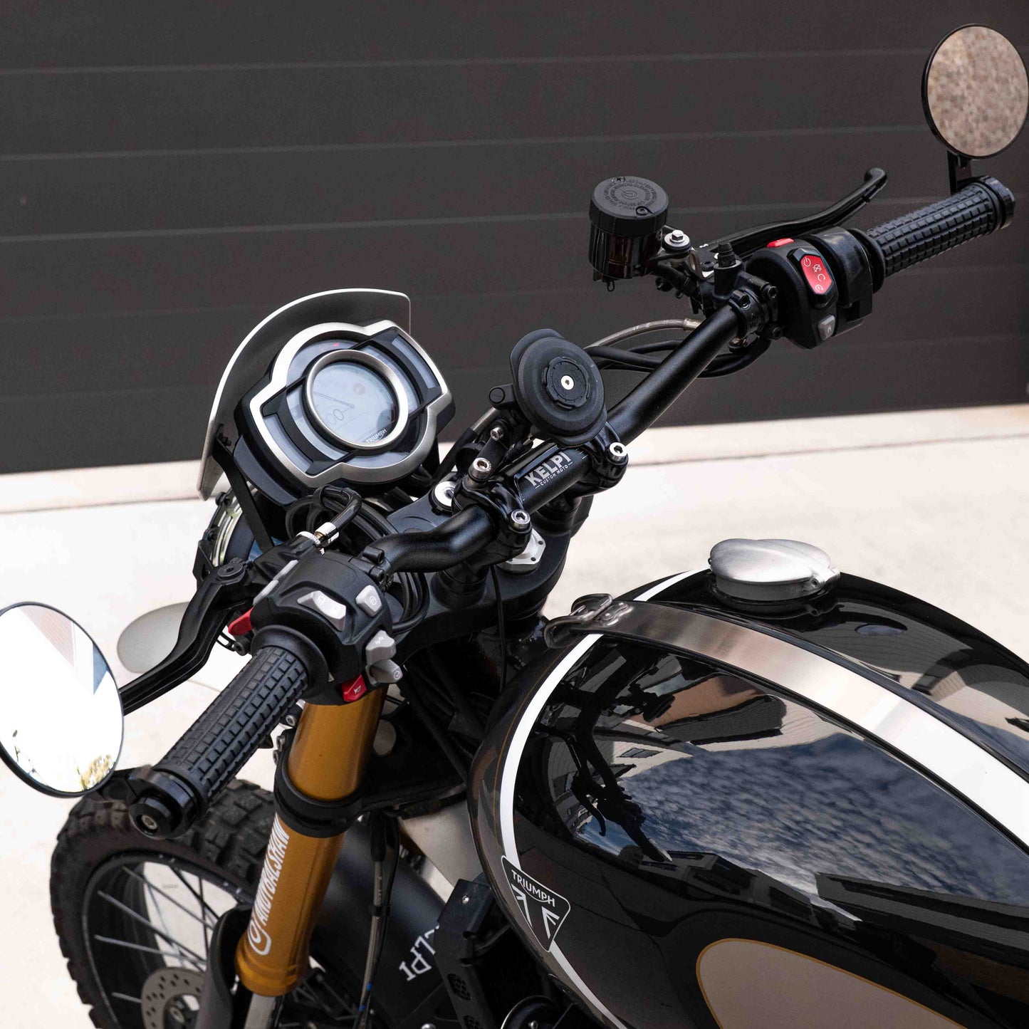 A triumph scrambler 1200 with a Kelpi Custom Moto Tracker 7050 Fat bars, rounder mirrors and fitzroy grips