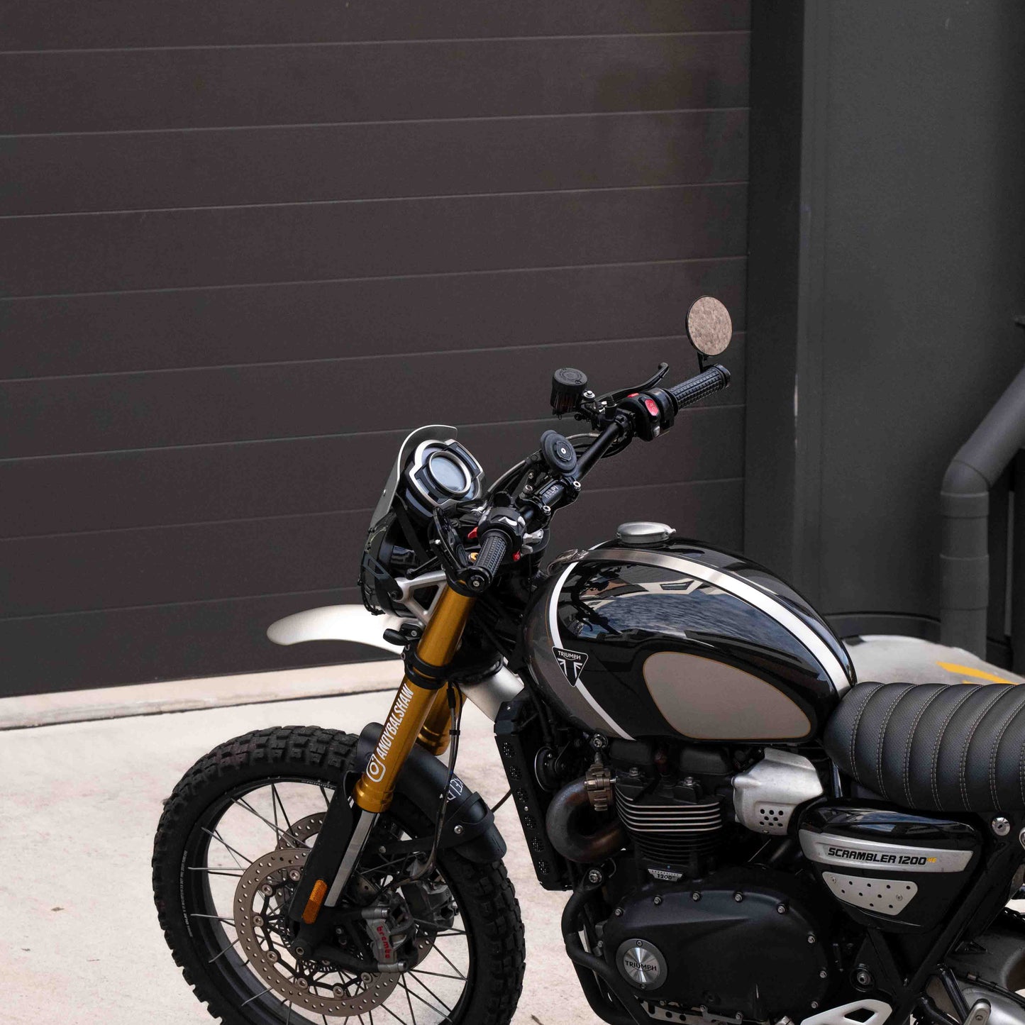 A triumph scrambler 1200 with a Kelpi Custom Moto Tracker 7050 Fat bars, rounder mirrors and fitzroy grips