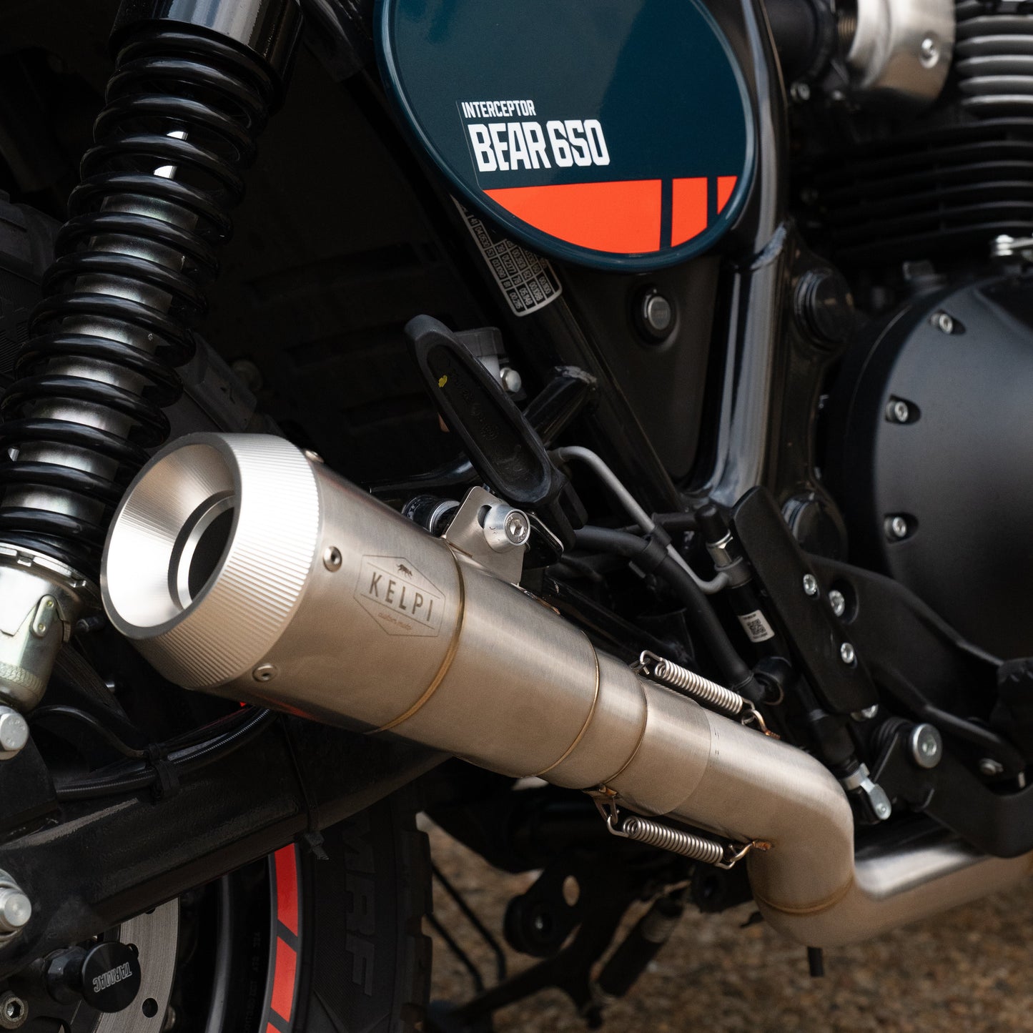 Close-up of a motorcycle exhaust with 'Kerr' branding on a textured surface