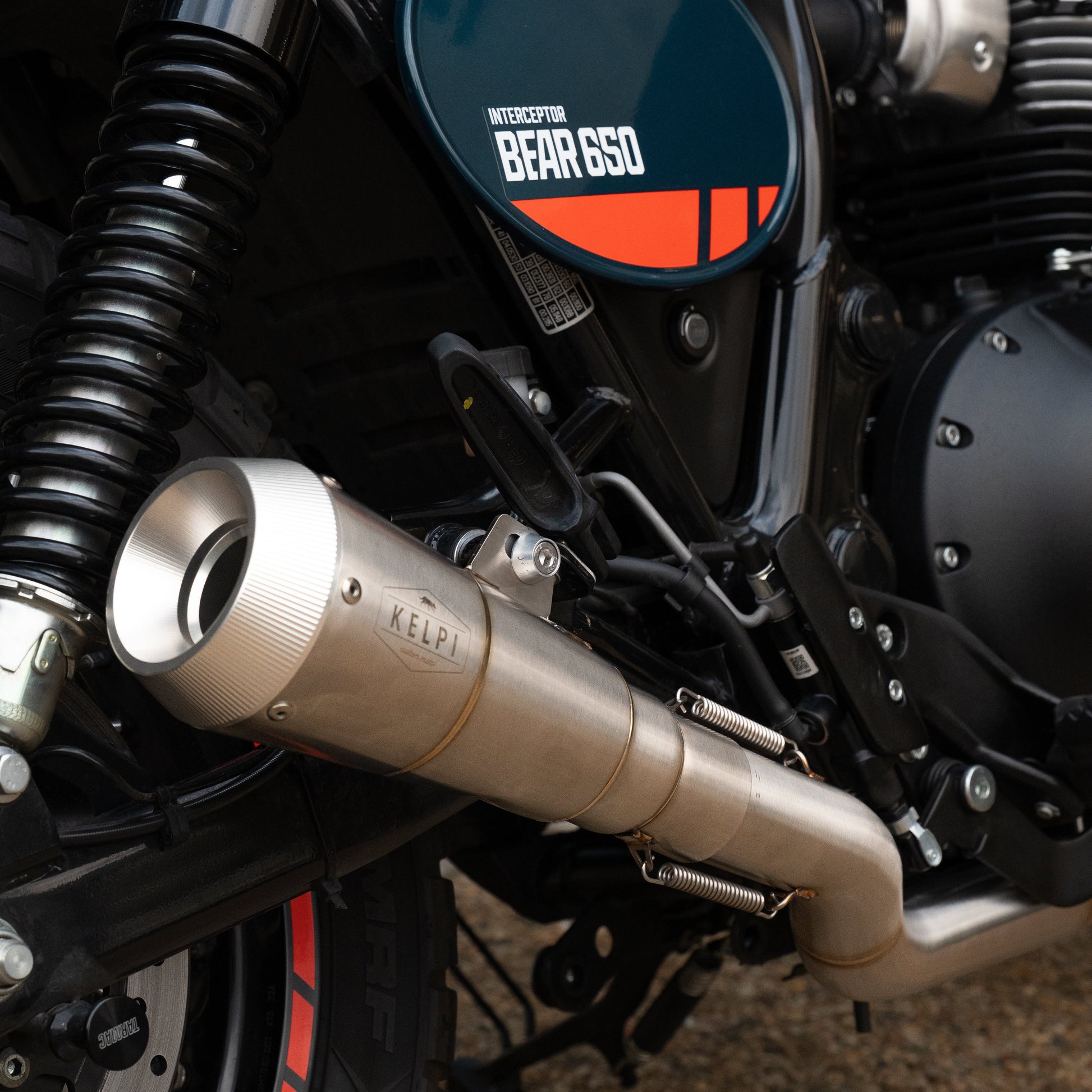 Close-up of a motorcycle exhaust with 'Kerr' branding on a textured surface