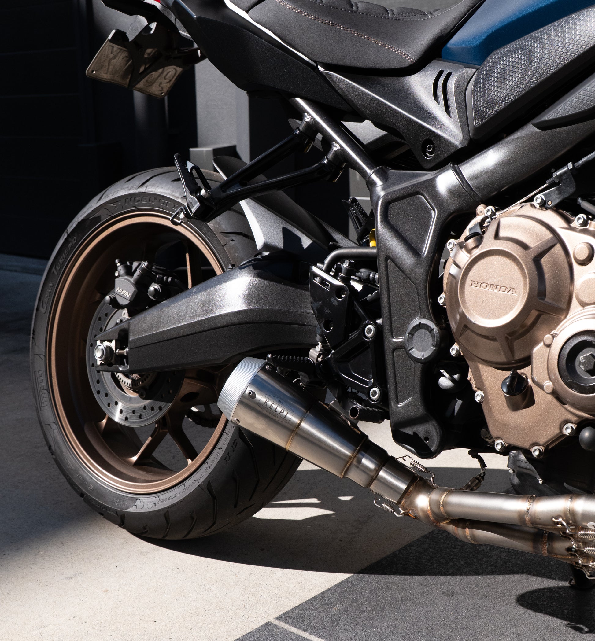 Close-up of a motorcycle's wheel and engine on a dark background