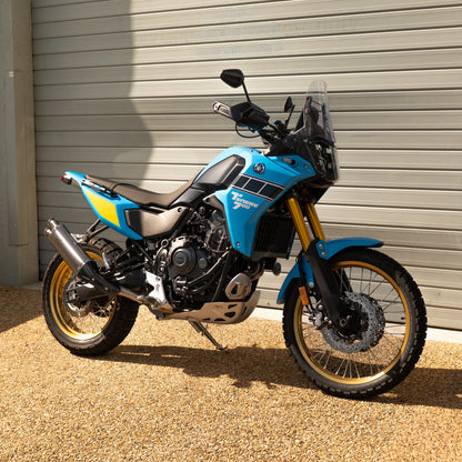 Blue motorcycle parked in front of a metallic garage door