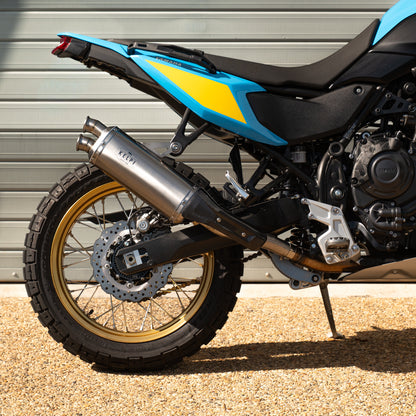 Motorcycle with blue and black design parked against a gray wall.