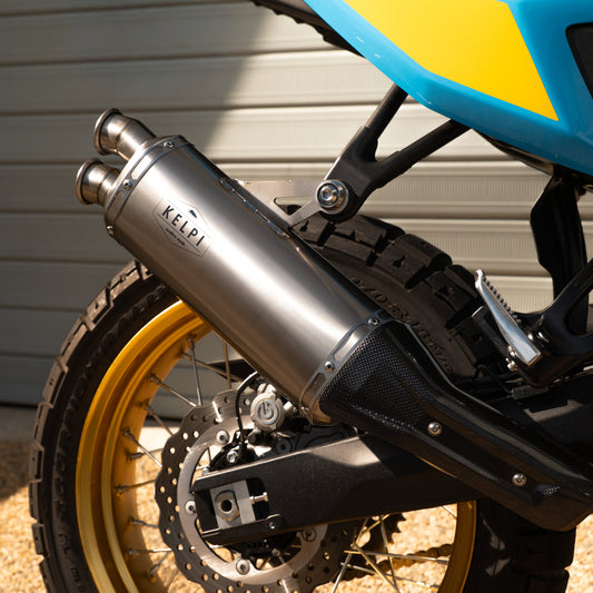 Close-up of a motorcycle's exhaust and wheel with a blurred background