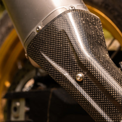 Close-up of a motorcycle exhaust with carbon fiber texture
